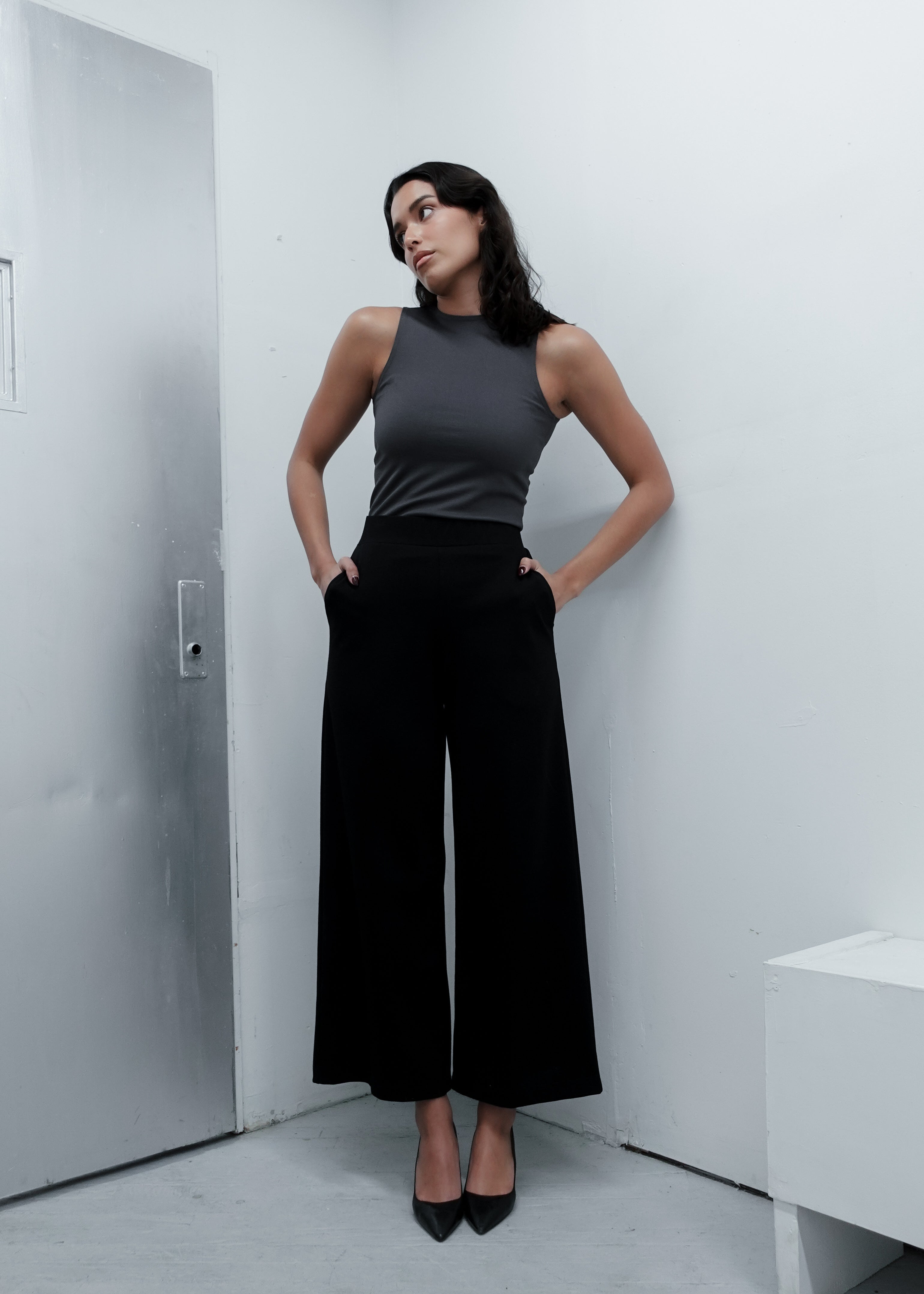 Woman in a pewter charcoal grey top and black wide-leg pants dressed for work professional office look.